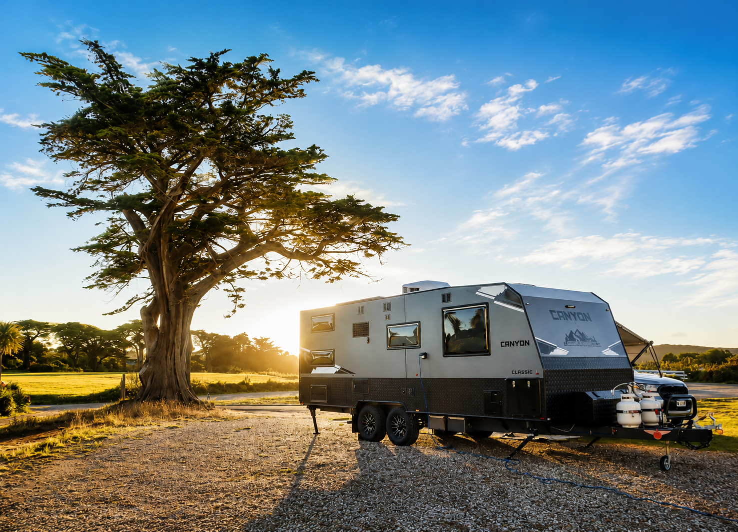 Canyon Classic caravan parked under a tree at sunset